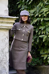 a lady in a grey jacket and skirt suit